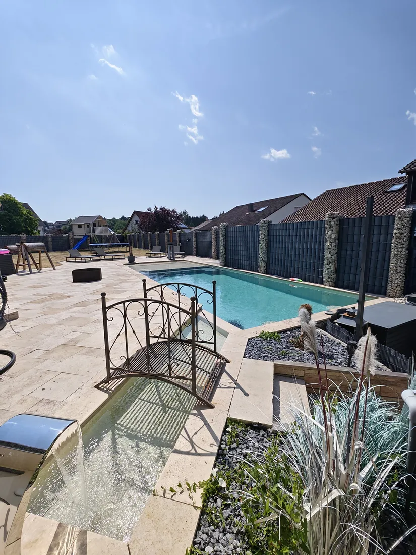 Pool mit Travertin-Terrasse, Zierbrücke und Edelstahl-Wasserfall, gebaut von SK Pools
