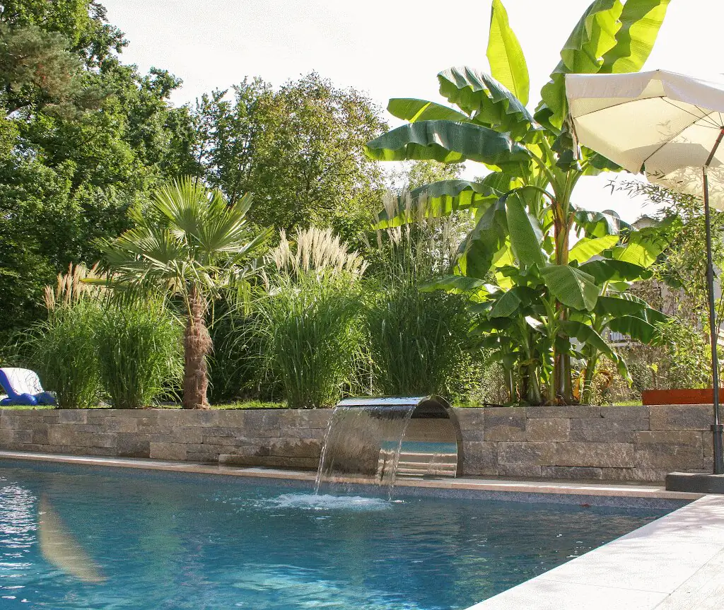 Pool mit Wasserfall, dahinter Palmen und Bananenstauden in Villingen-Schwenningen