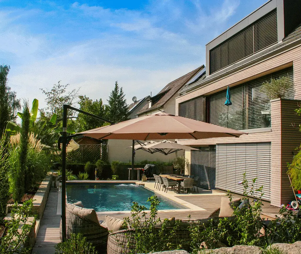 Gartenansicht mit Pool, Sonnenschirmen und Wohnhaus in Villingen-Schwenningen