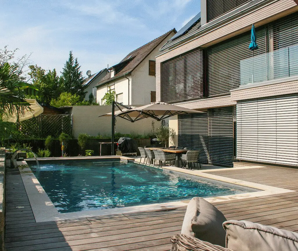 Pool mit Holzdeck und Sonnenschirm vor der Hausfassade in Villingen-Schwenningen