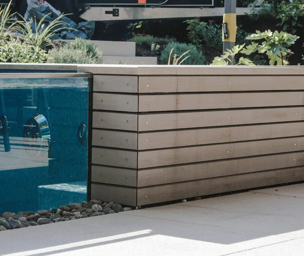 Glaswand des Pools mit Holzverkleidung und Kieselbett in Villingen-Schwenningen