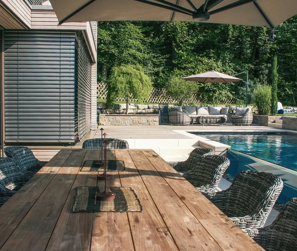 Esstisch unter dem Sonnenschirm, im Hintergrund der Pool in Villingen-Schwenningen