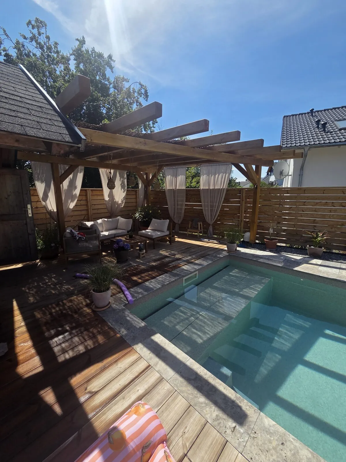 Pool mit Holzdeck unter der Pergola mit Loungebereich in Villingen-Schwenningen