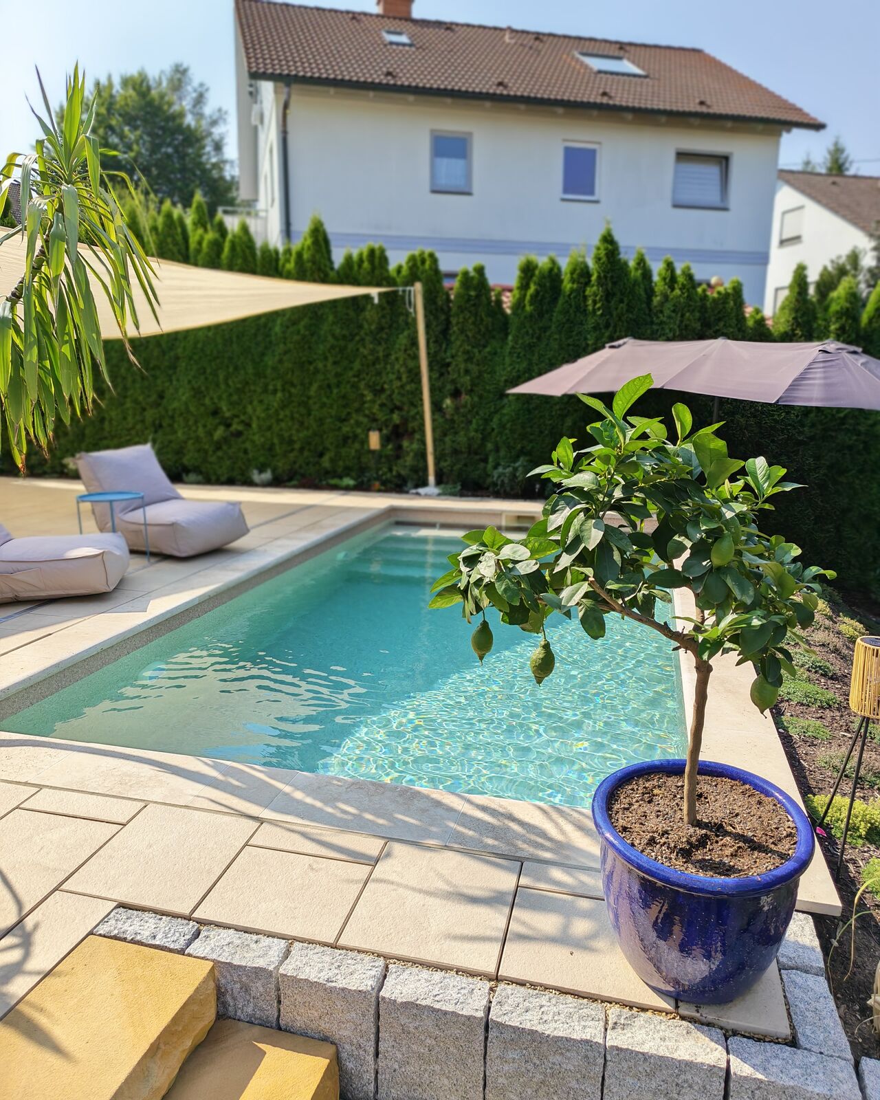Sandstein-Terrasse am Naturstein-Pool mit Sonnensegel
