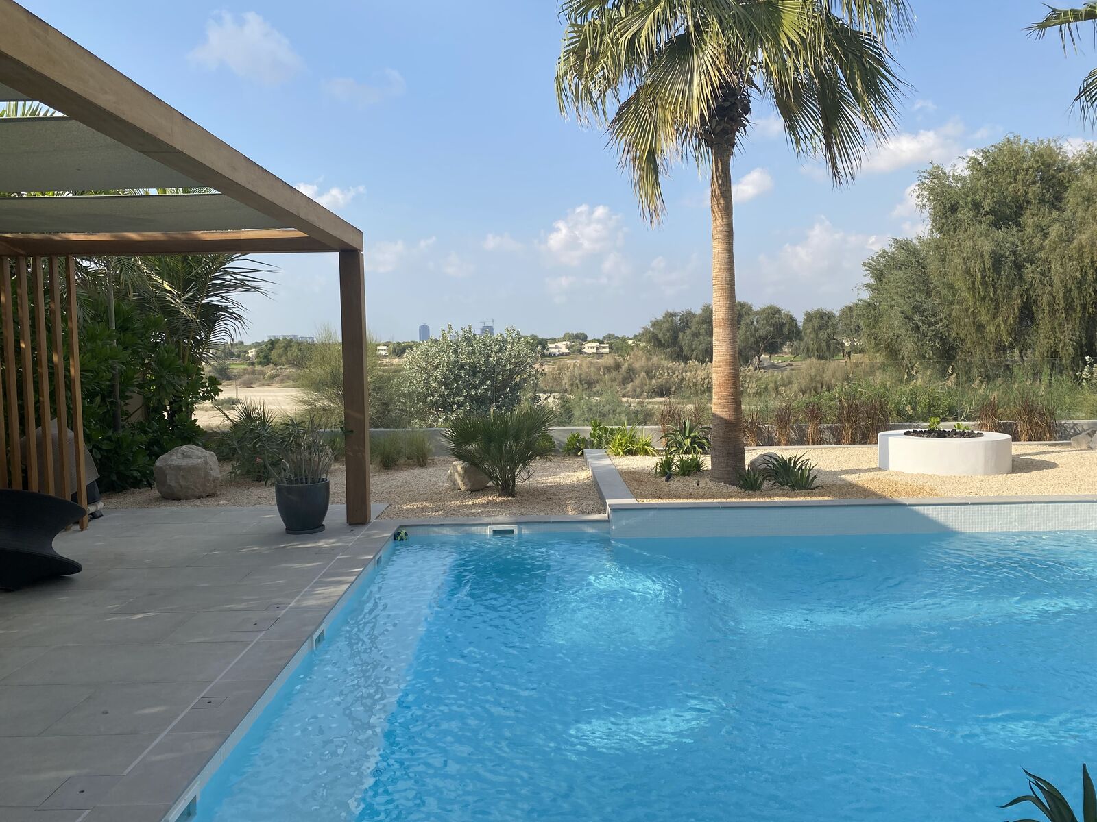 Detailansicht des Resort-Pools unter Palmen bei Sonnenlicht